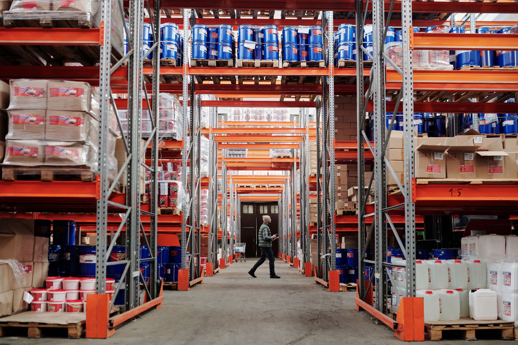 Warehouse worker walking between storage racks